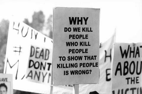A protester carries a sign from an anti-death penalty rally 